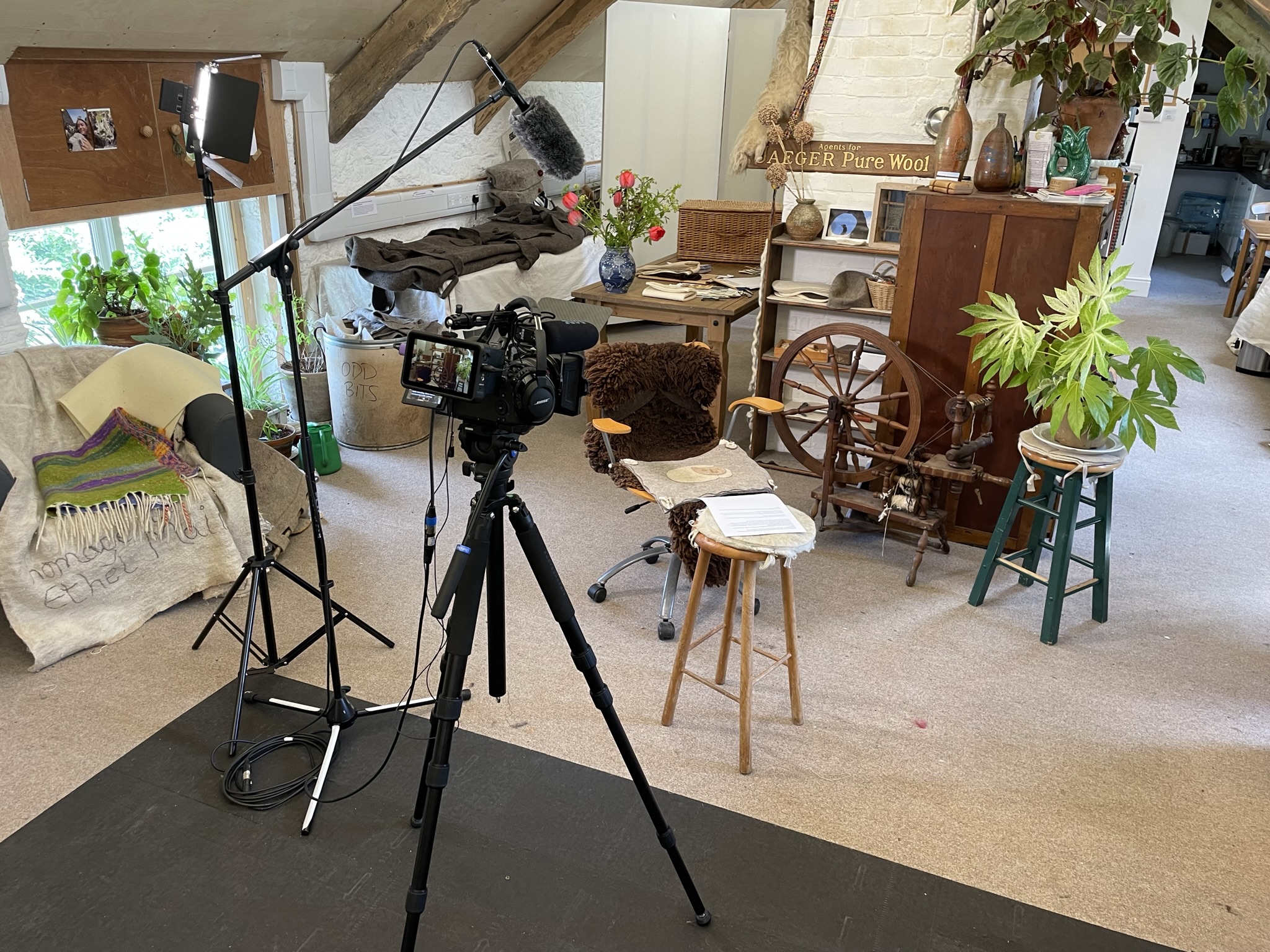 Professional video camera on tripod with LED light in a rustic studio setting