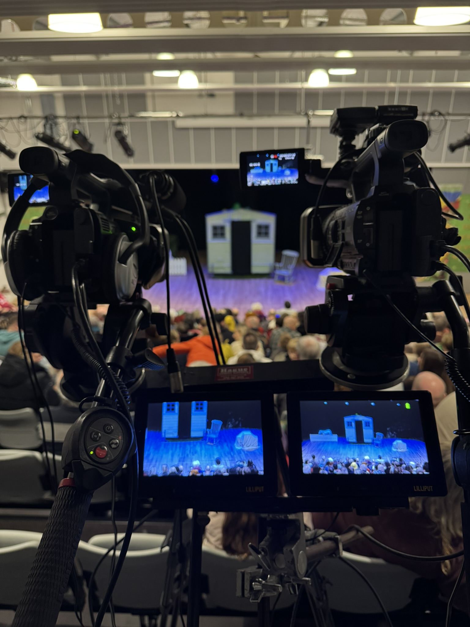 Twin camera rig on a shared bar with dual monitors, framed on a small theatre stage set
